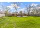 Spacious backyard with a patio, lush green lawn, mature trees, and a brick house at 5420 E 81St St, Indianapolis, IN 46250
