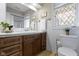 Bright bathroom featuring a wooden vanity, white subway tile, and a decorative window for a touch of elegance at 5420 E 81St St, Indianapolis, IN 46250