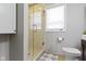 Bathroom with a glass shower door, a tiled shower and a window that brings in light at 5420 E 81St St, Indianapolis, IN 46250