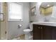 Modern bathroom with a round mirror, dark vanity, and a window for natural light at 5420 E 81St St, Indianapolis, IN 46250