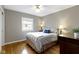 Comfortable bedroom with a queen-size bed, ceiling fan, and window offering natural light, creating a cozy retreat at 5420 E 81St St, Indianapolis, IN 46250