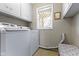 Functional laundry room equipped with a modern washer and dryer, overhead cabinets, and natural light from a window at 5420 E 81St St, Indianapolis, IN 46250