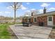 Outdoor patio with a table and chairs, brick home, with a well-maintained lawn at 5420 E 81St St, Indianapolis, IN 46250
