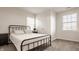 Bedroom with a wrought iron bed, white walls, and two windows allowing for lots of natural light at 564 N Beville Ave, Indianapolis, IN 46201