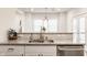 Close up of a kitchen with a granite countertop, stainless steel sink and appliances, and stylish backsplash at 564 N Beville Ave, Indianapolis, IN 46201