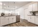 Bright, modern kitchen featuring white cabinets, granite countertops, stainless steel appliances, and stylish pendant lighting at 564 N Beville Ave, Indianapolis, IN 46201