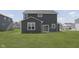 Spacious backyard with lush green grass, a dark grey house, and a patio at 5804 Summertree Pl, Whitestown, IN 46052