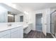 Bright bathroom with dual sinks, white cabinets, and a tiled shower area with glass door at 5804 Summertree Pl, Whitestown, IN 46052