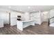 Modern white kitchen featuring a large island, stainless steel appliances, and hardwood floors at 5804 Summertree Pl, Whitestown, IN 46052
