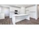 Modern white kitchen featuring a large island, stainless steel appliances and hardwood floors at 5804 Summertree Pl, Whitestown, IN 46052
