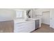 A bright kitchen boasts white cabinets, stainless steel appliances, and a large island with sleek countertops at 5804 Summertree Pl, Whitestown, IN 46052