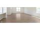 A large living room with hardwood floors and ample natural light, offering a seamless flow into the kitchen area at 5804 Summertree Pl, Whitestown, IN 46052