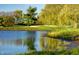 Picturesque view of a tranquil pond reflecting the surrounding lush landscape and golf course at 5804 Summertree Pl, Whitestown, IN 46052