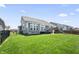 Fenced backyard, with green lawn, play structure, and a home exterior with large windows at 6472 W Treeline Ln, McCordsville, IN 46055