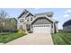 Inviting two-story house features a neatly kept lawn, a gray facade, and an attached two-car garage at 6472 W Treeline Ln, McCordsville, IN 46055