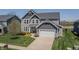 Charming gray two-story home showcasing a well-maintained lawn, professional landscaping, and a two-car garage at 6472 W Treeline Ln, McCordsville, IN 46055