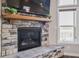Stone fireplace featuring a wooden mantel, a television, and adjacent windows at 6472 W Treeline Ln, McCordsville, IN 46055