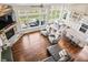 Open-concept living room featuring a stone fireplace, large windows, and hardwood floors at 6472 W Treeline Ln, McCordsville, IN 46055