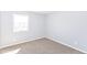 A bright bedroom features neutral walls and carpet, paired with a window, create a minimalist aesthetic at 718 Marie Ln, Fortville, IN 46040