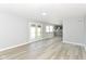 Open-concept living room and kitchen feature wood floors, neutral paint, and access to the outdoors via french doors at 718 Marie Ln, Fortville, IN 46040