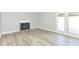Cozy living space features gas fireplace with brick surround, french doors to backyard, and wood floors at 718 Marie Ln, Fortville, IN 46040
