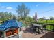 Spacious deck with seating, playhouse, and umbrella, overlooking the expansive green lawn for Gathering enjoyment at 7482 N Maple Dr, Frankton, IN 46044