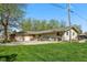 Charming single-story house with a spacious yard, mature trees, a basketball hoop, and a large driveway at 7482 N Maple Dr, Frankton, IN 46044