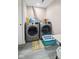 Modern laundry room with front-load washer and dryer, a laundry basket, and light luxury vinyl plank floor at 7482 N Maple Dr, Frankton, IN 46044