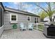 Cozy back deck with gray wood, a grill, and comfortable blue chairs for enjoying the outdoors at 7709 Lewis Rd, Indianapolis, IN 46256