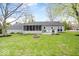 Beautiful backyard featuring a lush green lawn, a gray house, and a charming fire pit at 7709 Lewis Rd, Indianapolis, IN 46256