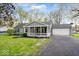 Charming single-story home with a well-manicured lawn, cozy porch, and attached garage at 7709 Lewis Rd, Indianapolis, IN 46256