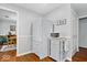 Functional kitchen area with a refrigerator, microwave on a rolling cart, and hardwood floors, conveniently located near the dining room at 7709 Lewis Rd, Indianapolis, IN 46256