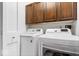 Well-equipped laundry room featuring a washer and dryer, along with upper cabinets for storage, adding convenience to chores at 7709 Lewis Rd, Indianapolis, IN 46256