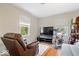 Cozy living room with an armchair, television, and natural light from windows, offering a comfortable relaxation space at 7709 Lewis Rd, Indianapolis, IN 46256
