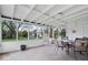 Relaxing sunroom featuring tile flooring, white ceiling beams, and a table set for outdoor dining at 7709 Lewis Rd, Indianapolis, IN 46256