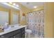 Well-lit bathroom featuring a vanity with a dark cabinet, a toilet, and a shower with a patterned curtain at 8158 Wheatfield Ct, Camby, IN 46113