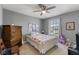 Charming bedroom with a ceiling fan, window, dresser, and a comfortable bed with colorful pillows at 8158 Wheatfield Ct, Camby, IN 46113