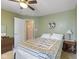 Cozy bedroom featuring a patterned quilt, ceiling fan, and a decorative floral wreath at 8158 Wheatfield Ct, Camby, IN 46113
