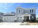 Two-story home with a two-car garage, grey siding and a brick entryway with white trim offers charming curb appeal at 827 Allandale Ave, Westfield, IN 46074