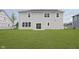 Backyard of home with a lush green lawn, sliding glass doors, and a neutral siding at 827 Allandale Ave, Westfield, IN 46074