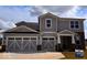 Charming two-story home featuring a three-car garage, gray siding, and a welcoming covered porch at 827 Allandale Ave, Westfield, IN 46074