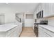 Open-concept kitchen featuring white cabinets, stainless steel appliances, a large island, and stylish flooring at 827 Allandale Ave, Westfield, IN 46074