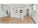 Bright, all-white kitchen featuring a large island, stainless steel appliances, and wood flooring at 827 Allandale Ave, Westfield, IN 46074