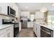 Modern kitchen features white cabinets, stainless steel appliances, and a view to the backyard at 827 Allandale Ave, Westfield, IN 46074
