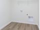 This compact laundry room features sleek plank flooring and practical utility hookups for modern convenience at 827 Allandale Ave, Westfield, IN 46074