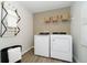 Bright laundry room features a modern washer and dryer, wooden floors, and a shelving unit with wicker baskets at 827 Allandale Ave, Westfield, IN 46074