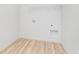 A bright laundry area with wood-look flooring and white walls is ready for outfitting at 827 Allandale Ave, Westfield, IN 46074