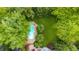 Aerial view of inground pool and backyard, surrounded by green trees and lush landscaping at 8535 Washington Blvd, Indianapolis, IN 46240
