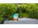 Aerial view of inground pool in backyard, surrounded by green trees and lush landscaping on a sunny day at 8535 Washington Blvd, Indianapolis, IN 46240