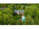 Aerial view of brick home with inground pool, surrounded by green trees and lush landscaping at 8535 Washington Blvd, Indianapolis, IN 46240